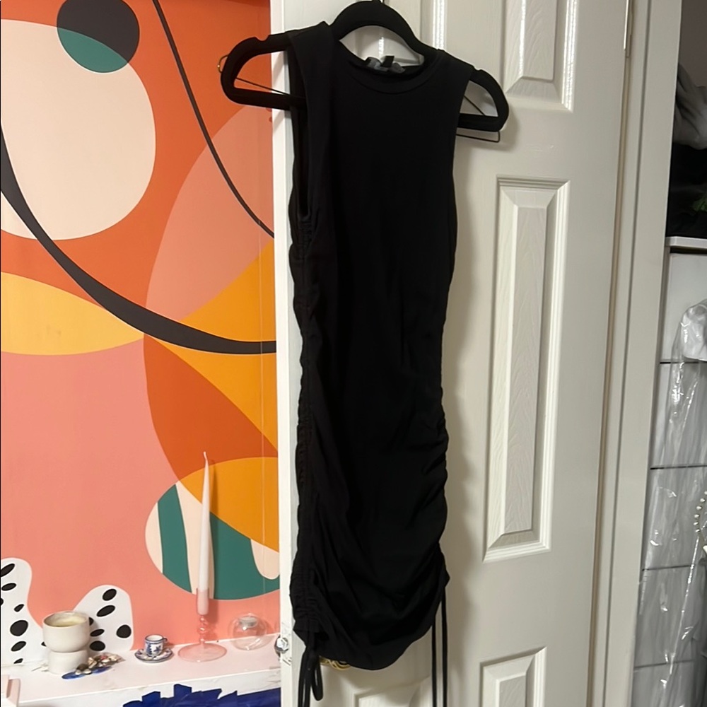 Black mini dress with cords on side to make longer or shorter